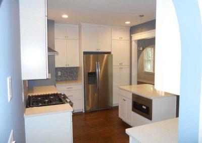 Modern renovated kitchen with white cabinets and stainless steel appliances. This was renovated after a fire destroyed the house.