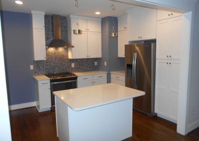 Modern renovated kitchen with blue walls and white cabinetry. This was renovated after a fire destroyed the house..