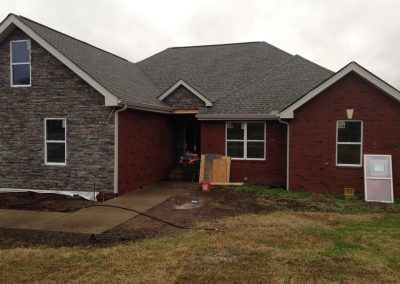 Stone and red brick home during the renovation stage after a complete fire loss