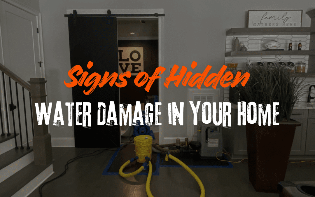 A professional water restoration setup in a modern living area with industrial drying equipment, hoses, and dehumidifiers on dark wood flooring. The image features the text "Signs of Hidden WATER DAMAGE IN YOUR HOME" in orange and white.