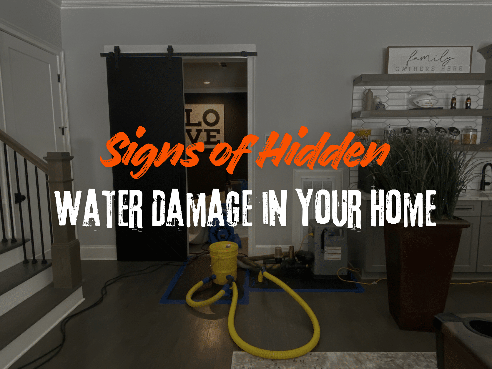 A professional water restoration setup in a modern living area with industrial drying equipment, hoses, and dehumidifiers on dark wood flooring. The image features the text "Signs of Hidden WATER DAMAGE IN YOUR HOME" in orange and white.