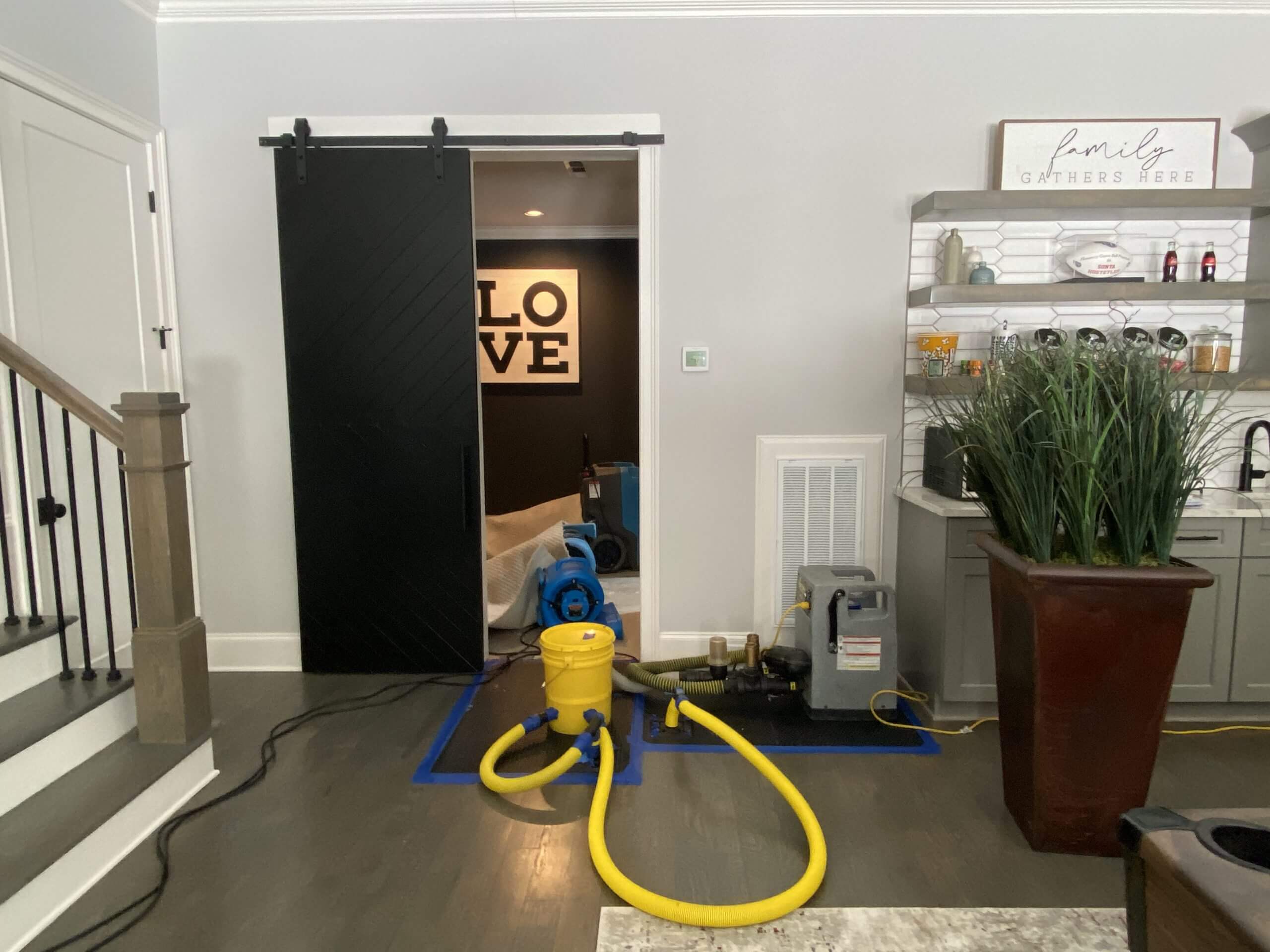 A room with nashville water damage restoration equipment. An air scrubber, dehumidifier, and drying mats are set up to remove moisture and prevent mold growth.